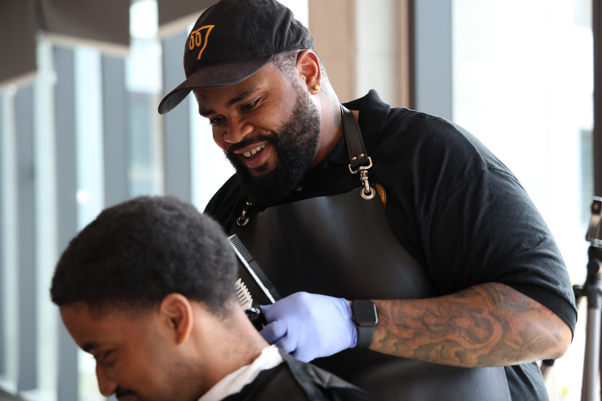 Ronald Montgomery cuts a customer's hair during a free haircut event at West Grove Commons on Thursday, Feb. 27, 2025. (Braelyn Furse / Golden Gate Xpress)