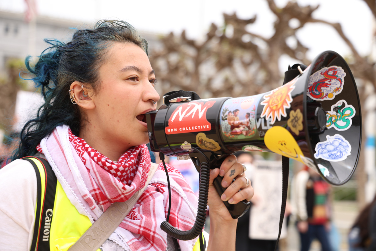 A protester chants into a megaphone during a protest in front of San Francisco City Hall during the National Day of Action for Higher Ed on Thursday, April 17, 2025. (Braelyn Furse / Golden Gate Xpress)